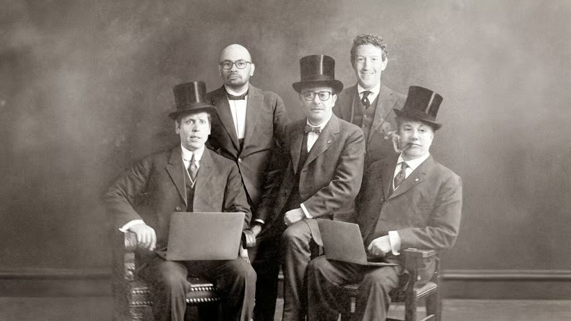 Fotomontaje en sepia al estilo de un retrato de estudio del siglo XIX: cinco hombres con sombrero de copa y levita posan juntos, y dos de ellos, sentados, sostienen computadores portatiles sobre las rodillas